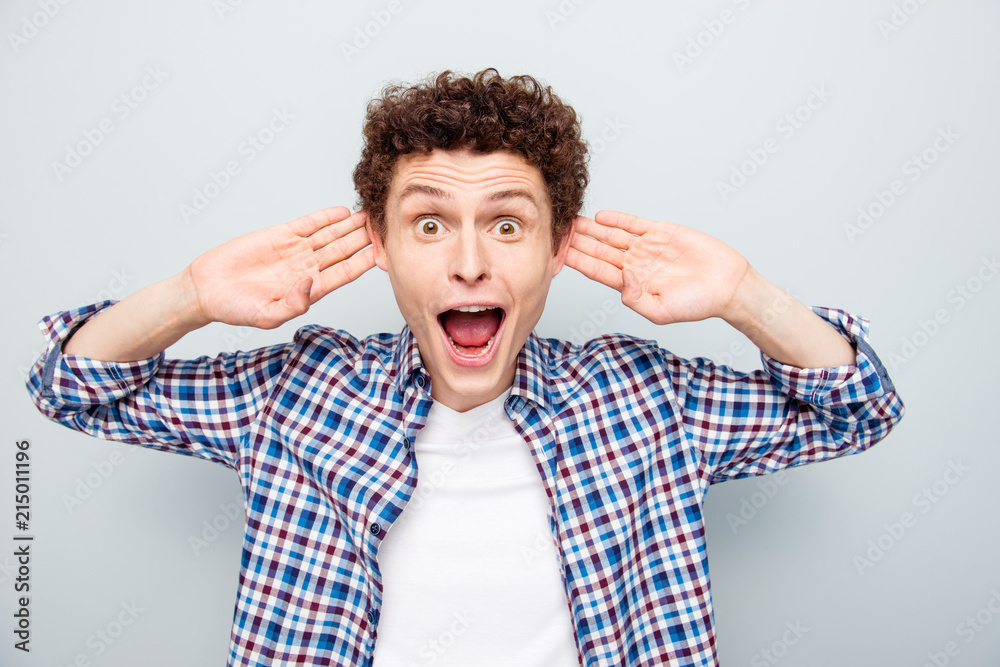 I cannot believe it! You heard? Close up portrait of crazy guy looks in camera with wide open mouth and eyes, clasped to his ears trying to hear the news isolated on light gray background I cannot believe it! You heard? Close up portrait of crazy guy looks in camera with wide open mouth and eyes, clasped to his ears trying to hear the news isolated on light gray background