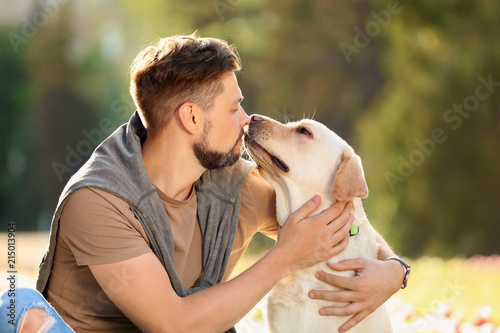 Cute yellow labrador retriever with owner outdoors © New Africa