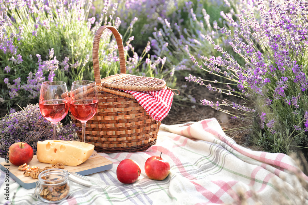 Obraz premium Zestaw na piknik na kocu w lawendowym polu
