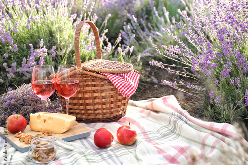 Fototapeta Naklejka Na Ścianę i Meble -  Set for picnic on blanket in lavender field