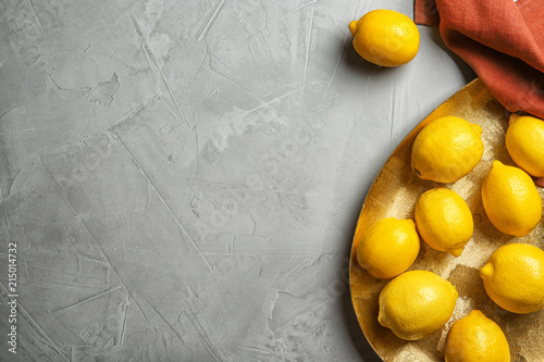 Flat lay composition with plate of lemons on gray background