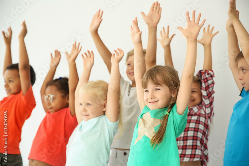 Little children raising hands together on light background. Unity concept