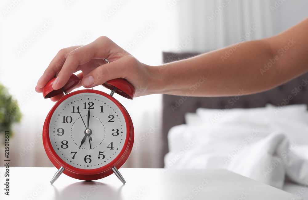 Woman turning off alarm clock on table in bedroom. Time to wake up Stock  Photo | Adobe Stock