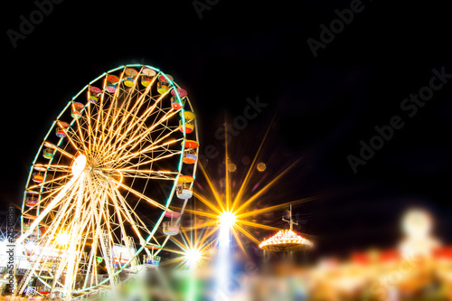 Ferris wheel in motion at amusement park at night