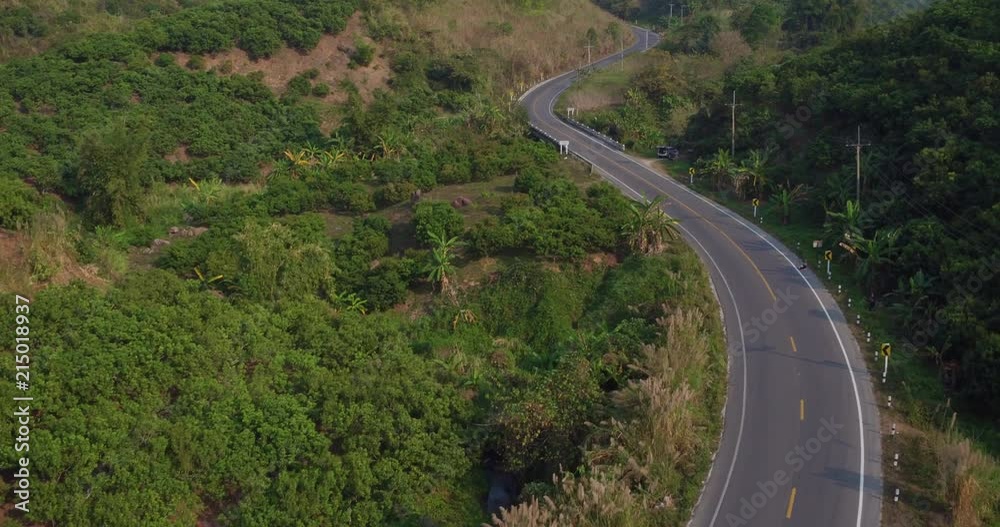 A Ducati Multistrada 1200 (2016 model) motorcycle being ridden through the countryside of Chiang Rai, Northern Thailand. Beautiful jungle scenery lines the roads. A Ducati Multistrada 1200 (2016 model) motorcycle being ridden through the countryside of Chiang Rai, Northern Thailand. Beautiful jungle scenery lines the roads.