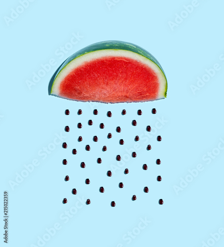 Watermelon and seeds rain concept on a blue background