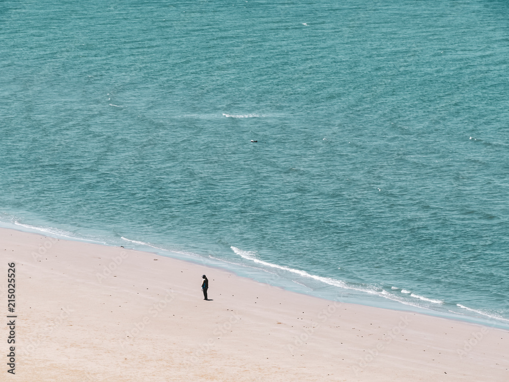 a man stand alone on the beach