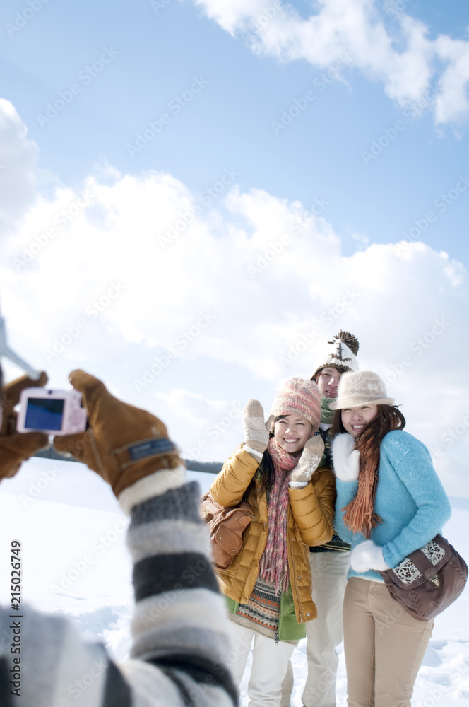 雪原で記念写真を撮る若者たち