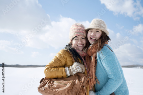 雪原で微笑む2人の女性