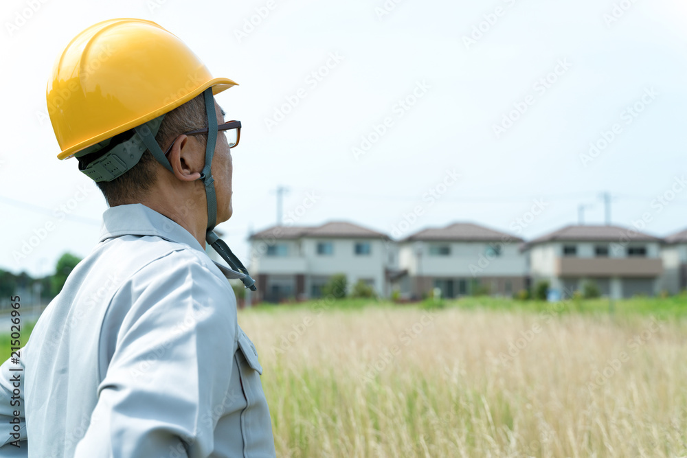 住宅街と更地を見つめる不動産デベロッパー 住宅街と更地を見つめる不動産デベロッパー