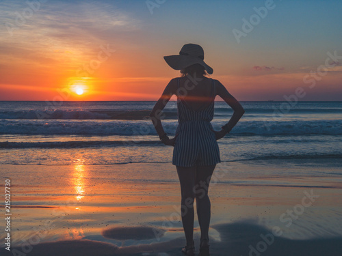 Silhouette of a girl in sunset / sunrise time over the ocean. #215027730