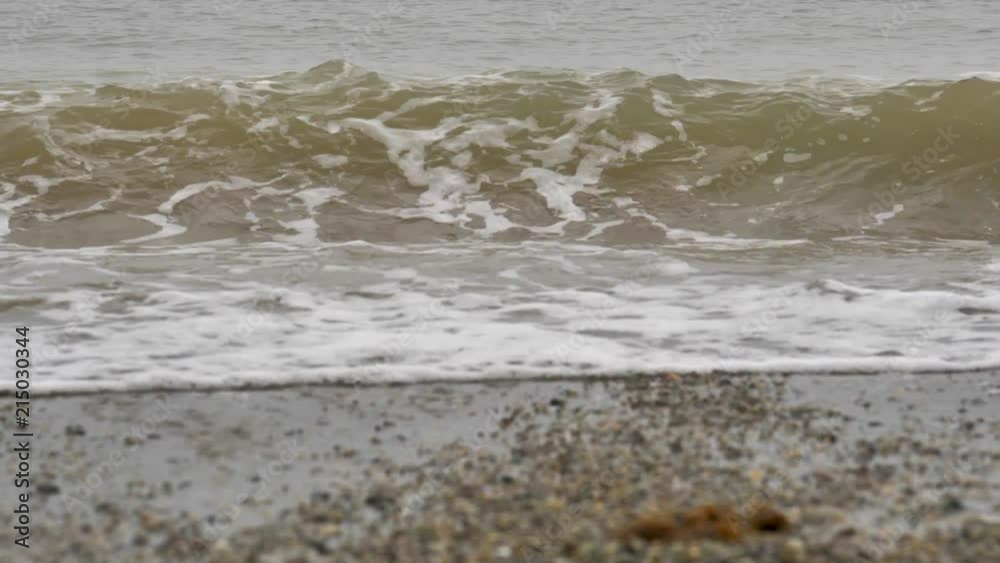 Slow Motion ocean wave transparent water crushing and splashing on rocky beach on Canadian coast, on a cloudy, foggy, grey day. Slow Motion ocean wave transparent water crushing and splashing on rocky beach on Canadian coast, on a cloudy, foggy, grey day.