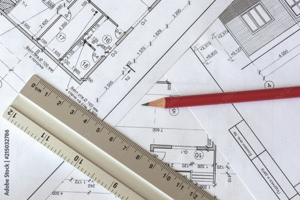 The architectural plan of the house is printed on a white sheet of paper. A red pencil and a ruler on it. June 2018, Russia, Moscow The architectural plan of the house is printed on a white sheet of paper. A red pencil and a ruler on it. June 2018, Russia, Moscow
