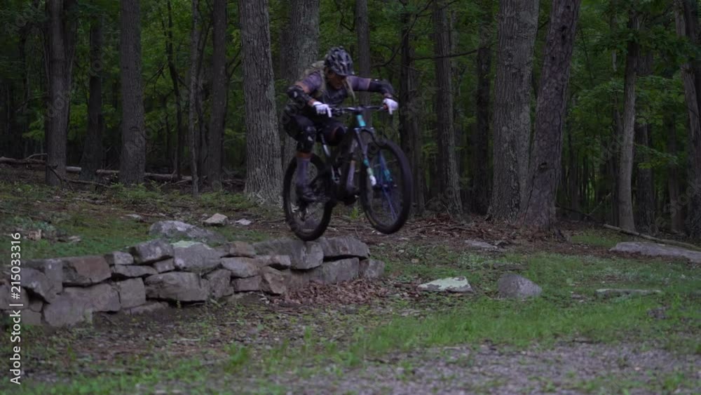 Speed ramping as two mountain bikers jump off of a wall. Speed ramping as two mountain bikers jump off of a wall.