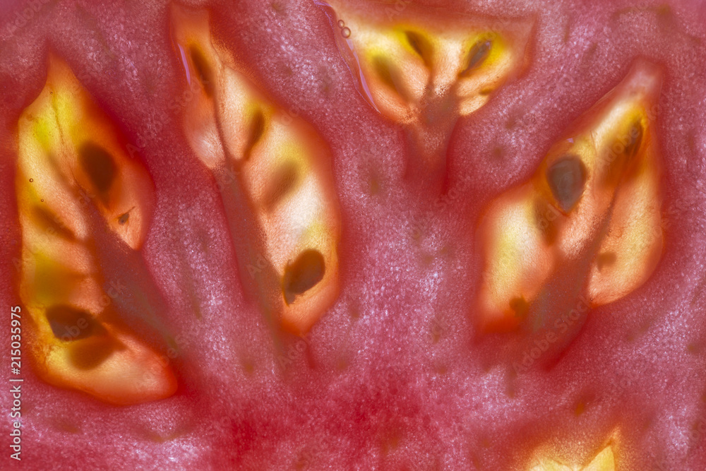 Red tomato slice background, top view, closeup, macro Red tomato slice background, top view, closeup, macro