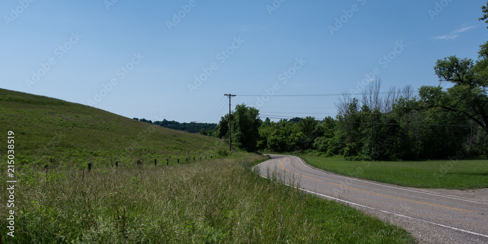 Panorama of road curving around hill