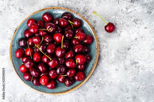 Ripe burgundy cherry in bowl on table