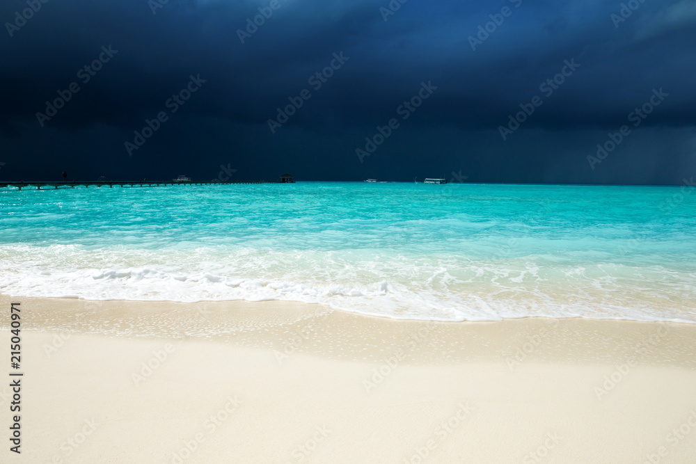 tropical beach in Maldives with few palm trees and blue lagoon