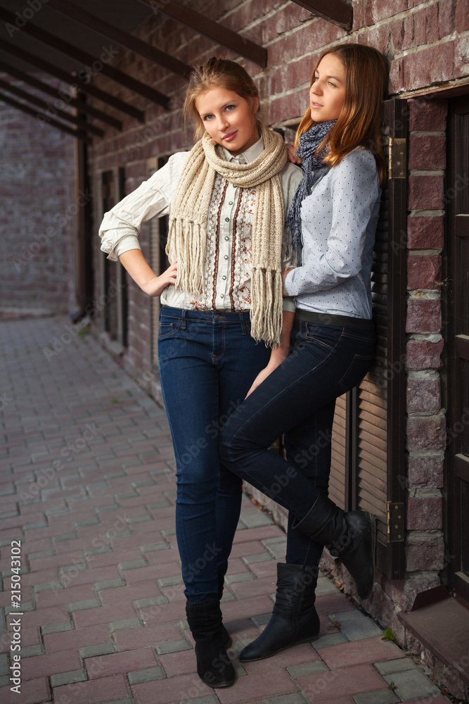 Two young fashion girls in white shirt and dark blue jeans Stock Photo