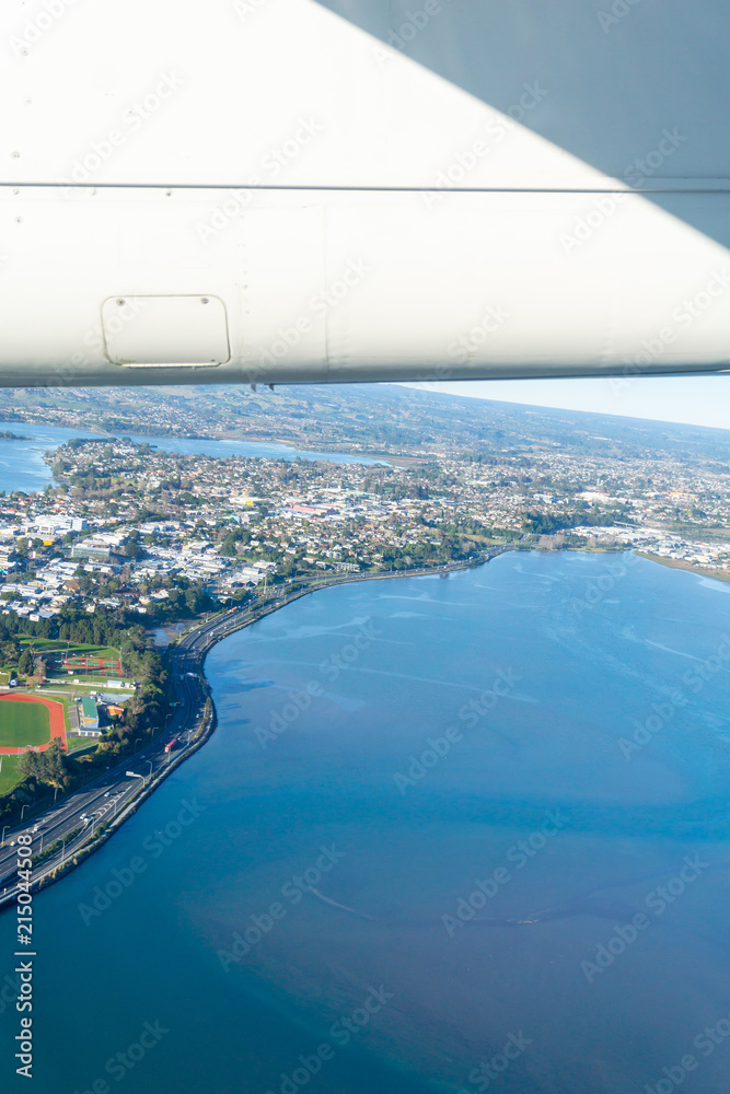 Fototapeta premium Tauranga harbour and urban peninsula aerial image with plane wing