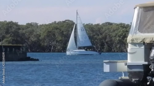 slow shots of sail boats and a luxury cruiser passing by near the Runaway Bay Marina on the Gold Coast, Australia photo