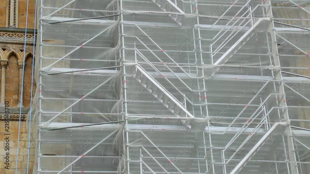 The netting of scaffolding on a cathedral blowing in the wind in slow motion.