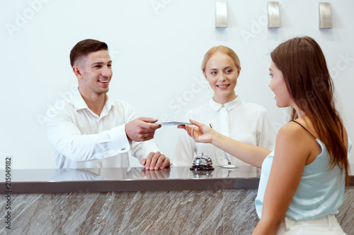 Woman Checking In At Hotel Reception