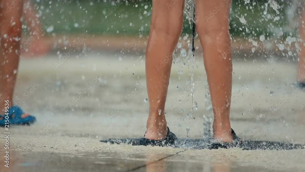 Closeup up of child's feet playing and running through fountain in public park. Shallow depth of the field, toned video, 50fps. Closeup up of child's feet playing and running through fountain in public park. Shallow depth of the field, toned video, 50fps.