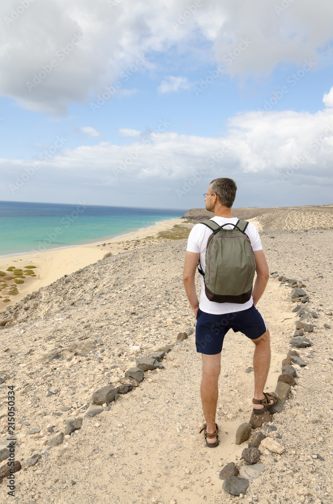 A tourist with a backpack admiring the sea view