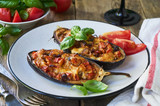 Stuffed eggplants with tomatoes and cheese on a plate     