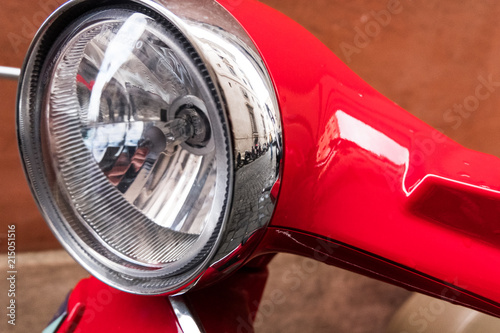 Wallpaper background of front light design of a red scooter .