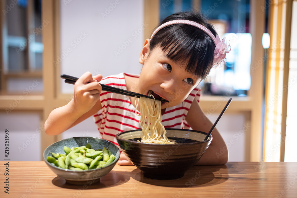 Asian little Chinese girl eating ramen noodles Asian little Chinese girl eating ramen noodles
