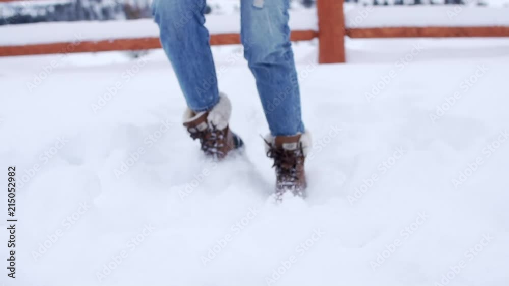 Woman playing around kicking the snow in high quality fashion boots
