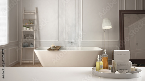 Spa  hotel bathroom concept. White table top or shelf with bathing accessories  toiletries  over blurred scandinavian bathroom  modern architecture interior design