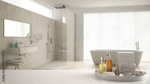 Spa  hotel bathroom concept. White table top or shelf with bathing accessories  toiletries  over blurred cream minimalist bathroom  modern architecture interior design