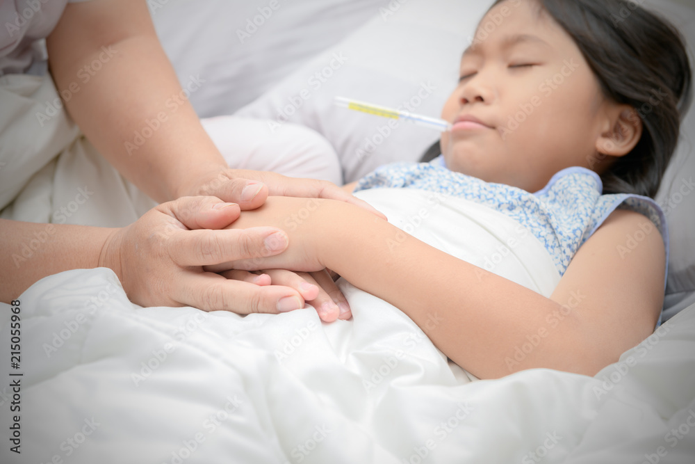 Hands of mother and sick asian daughter holding together in home. Hands of mother and sick asian daughter holding together in home.