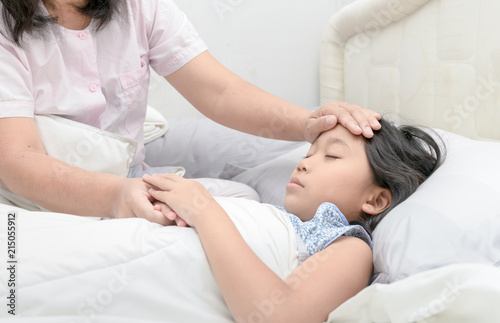 Mother measuring temperature of her ill kid.