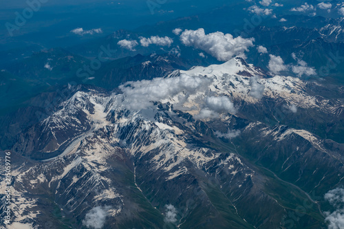 Aerial view of the Kazbek mountain and mountain range which partially covered by the snow on the top during the summer time