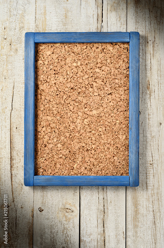 corkboard with blue fame on wooden wall photo