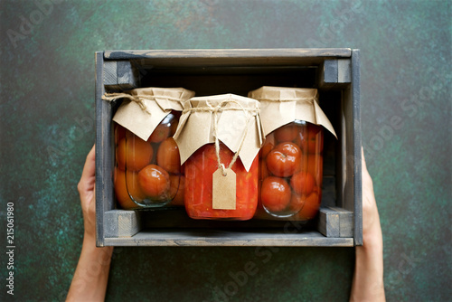 Autumn preserves of tomatoes and vegetable puree in glass jars placed in wooden box. Homemade autumn canning products
 photo