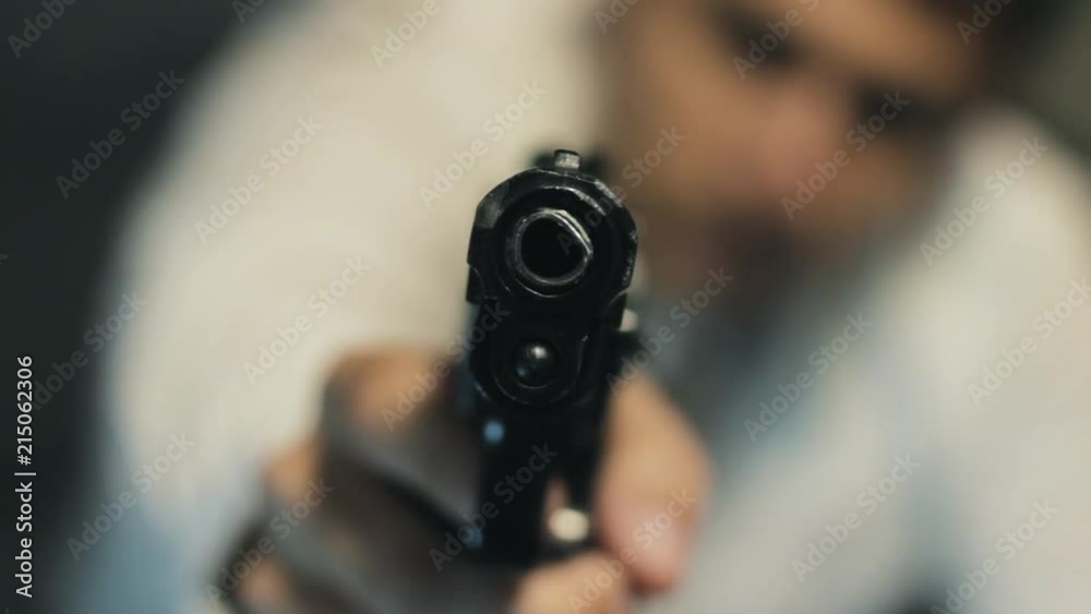 man with a gun aiming at the camera