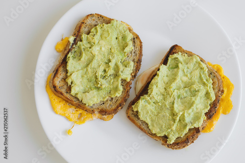 Two hot toasts with whole grain bread, eggs and avocado. Breakfast food. Healthy eating concept