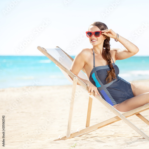 woman looking into the distance while sitting in a beach chair