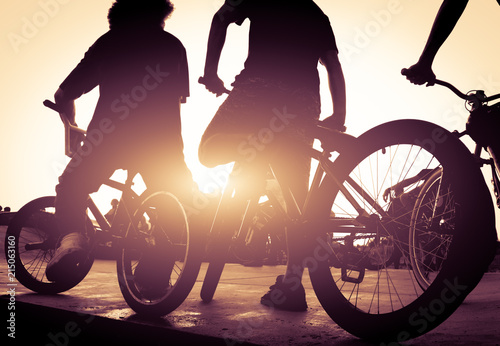 Cyclists on the ramp for jumping at sunset.