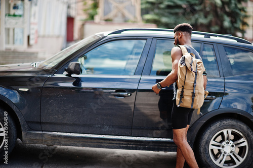 African american male athlete sport man with backpack against his black suv car before training.