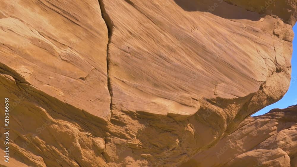 Close up of orange grindstone cliff in Canada, on peaceful and sunny day at the beach.