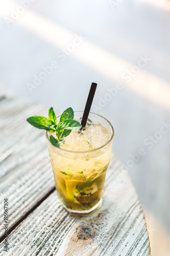 Mojito cocktail on the wooden table at a sunny day