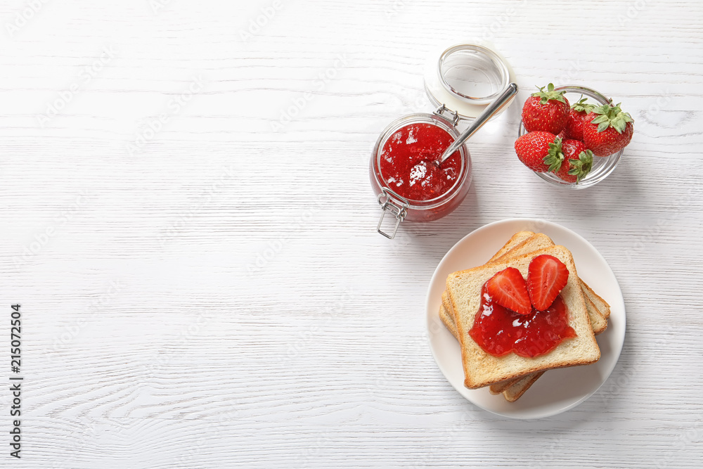 Flat lay composition with toast bread, strawberry jam and fresh berries on light background Flat lay composition with toast bread, strawberry jam and fresh berries on light background