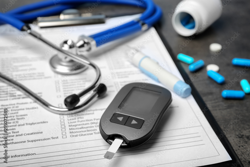Composition with form for laboratory test, digital glucometer, medicine and stethoscope on table, closeup. Diabetes concept