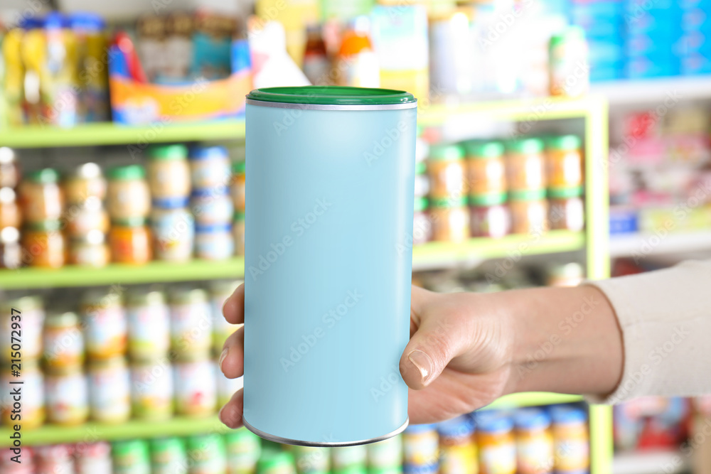 Woman holding can with baby milk formula in store Woman holding can with baby milk formula in store